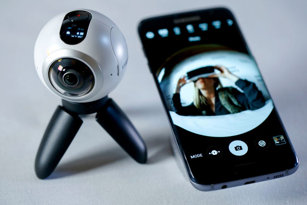 An employee demonstrates the previously released Samsung Electronics Co. Gear VR, visible on the Samsung Galaxy S7 edge with 3D thermo forming, right, alongside the new Samsung Gear 360, video camera, left, which sends 360 degree footage to the mobile device in this arranged photo in London, U.K., on Thursday, Feb. 18, 2016. Samsung showed off new Galaxy S7 smartphones featuring upgraded components and the return of a popular feature missing from their predecessors, in the latest attempt to breathe life into its premium line and wrest ascendancy back from Apple Inc. Photographer: Luke MacGregor/Bloomberg